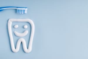 Toothbrush and tooth paste on a blue background